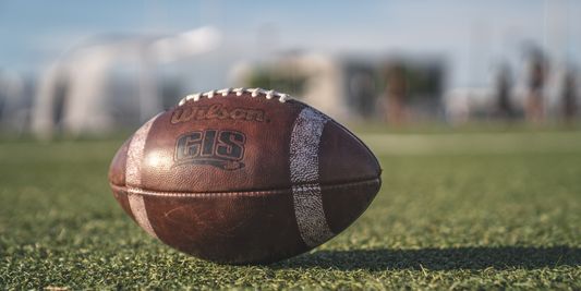 football laying on a football field with a blurred background